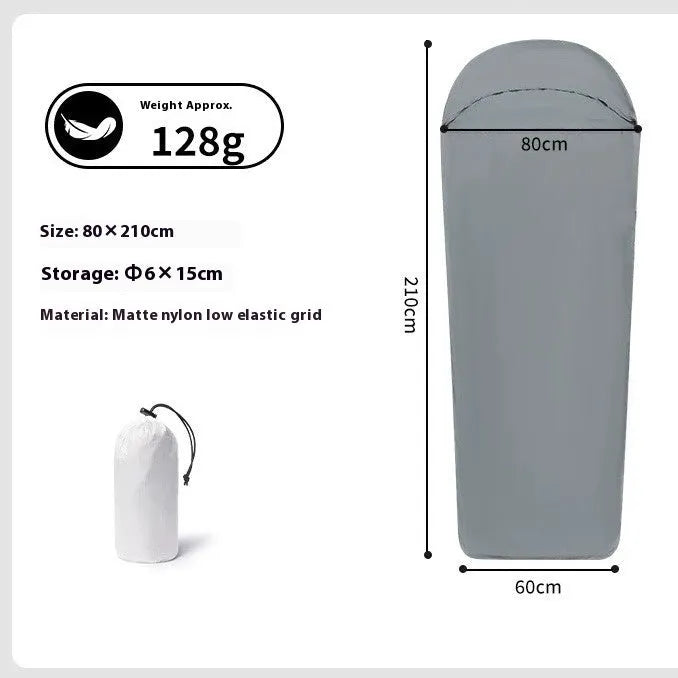 Blue lightweight mummy-style nylon sleeping bag with tapered foot, shown rolled up for travel.