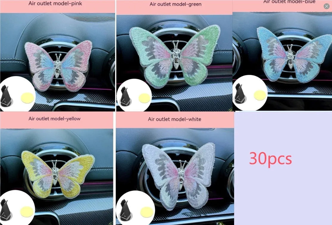 Soft fabric embroidered butterfly car air vent decoration in multiple colour options on a centre console.