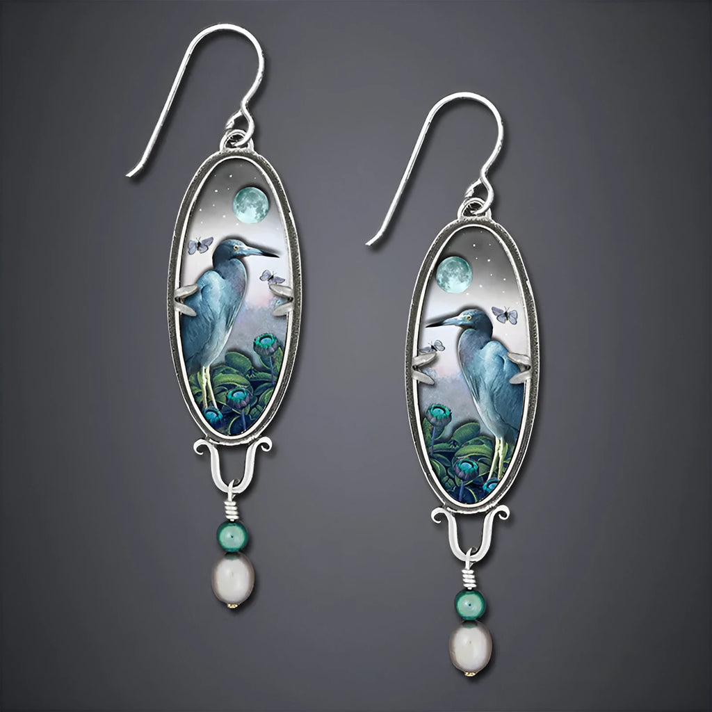 Silver drop earrings with a detailed bird and flower motif on a retro design.