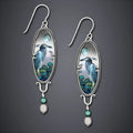 Silver drop earrings with a detailed bird and flower motif on a retro design.