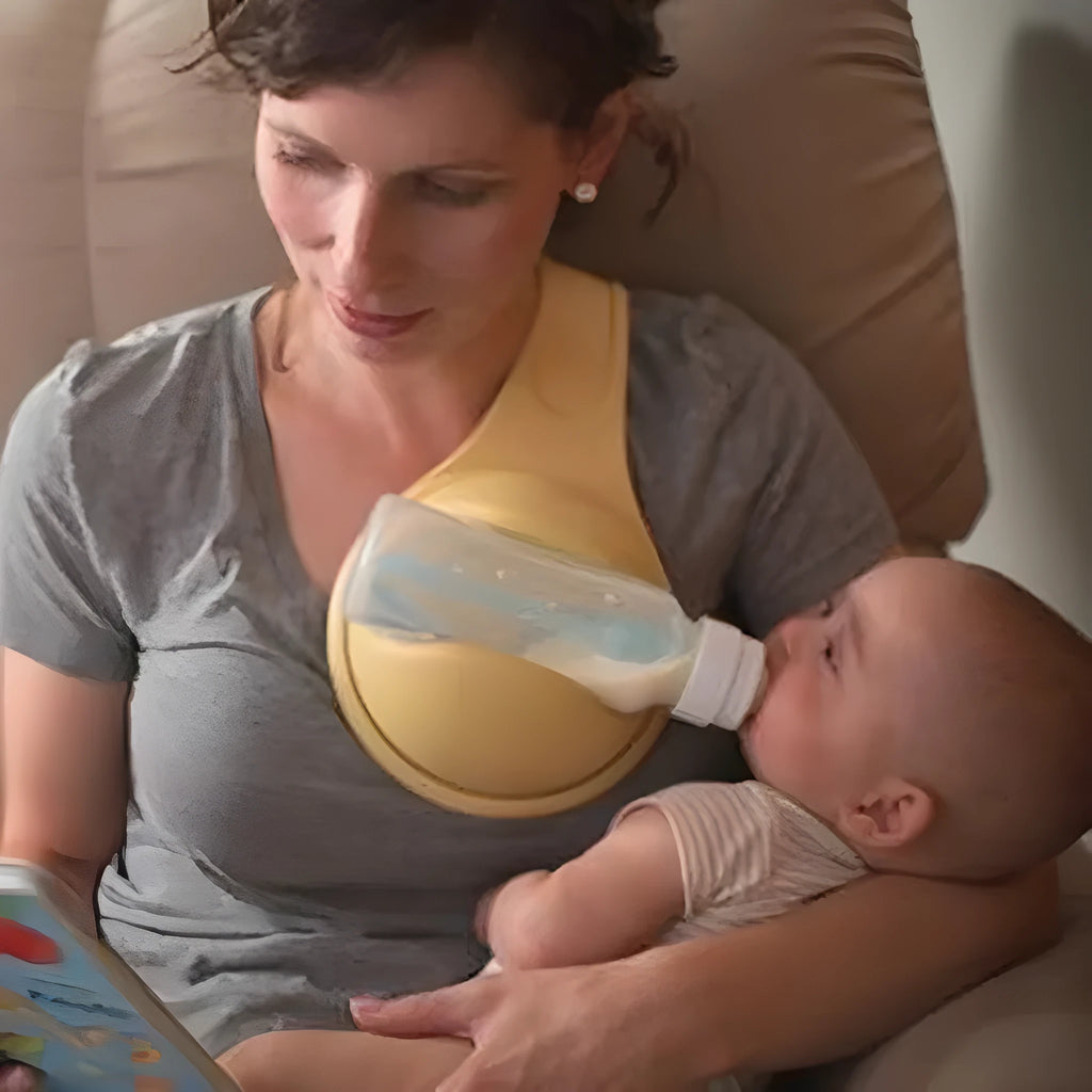 Yellow plastic hands-free baby bottle holder on a white surface, showing the bottle slot and ergonomic curve, 48x16x13cm