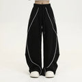 Black striped pleated hip-hop wide-leg sports pants on a hanger.
