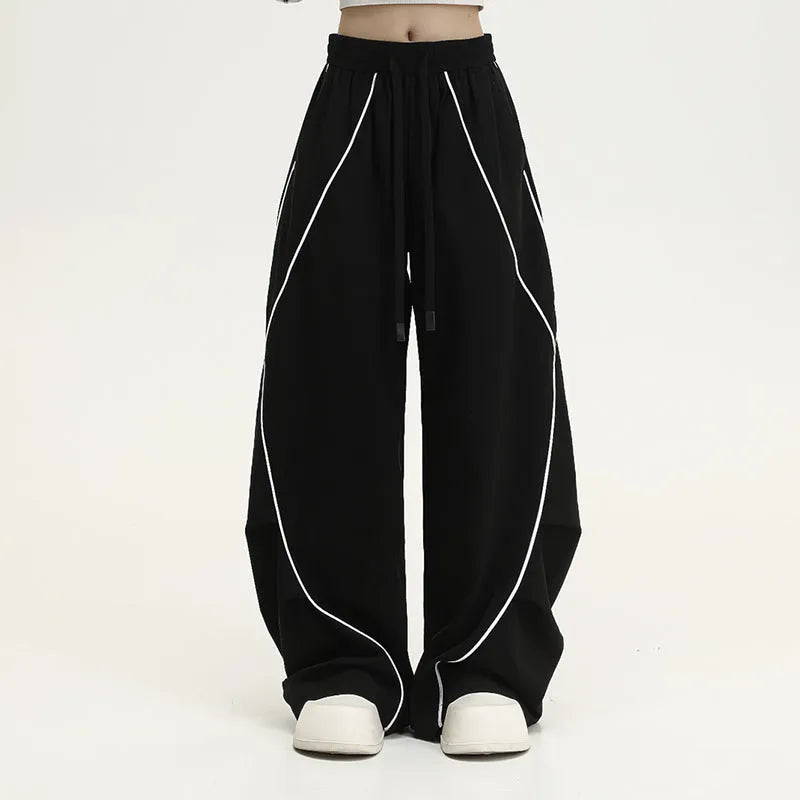 Black striped pleated hip-hop wide-leg sports pants on a hanger.