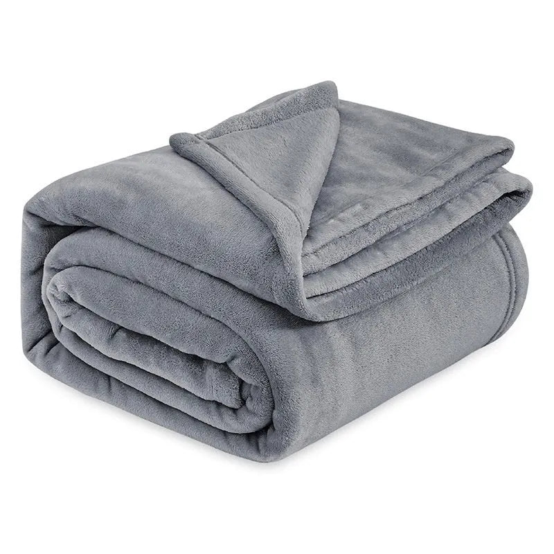 Light gray coral flannel polyester air conditioning blanket folded on a neutral background