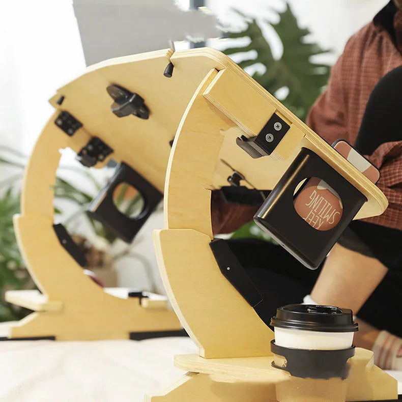 White maple wooden bed table holding a laptop at an angle, folded legs visible on a duvet.