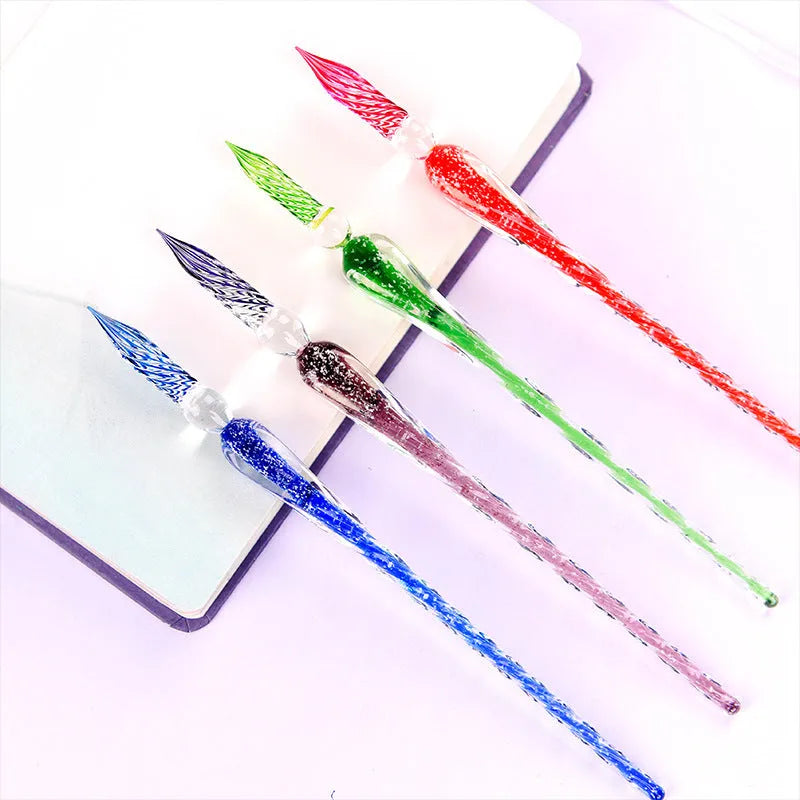 Clear glass dip pen with twisted tip resting on a table, available in multiple colours