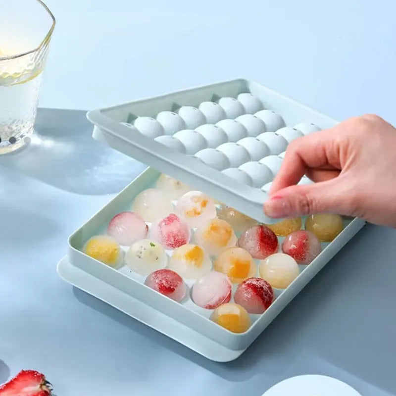 Blue silicone ice cube tray with lid showing 33 round moulds for homemade ice.