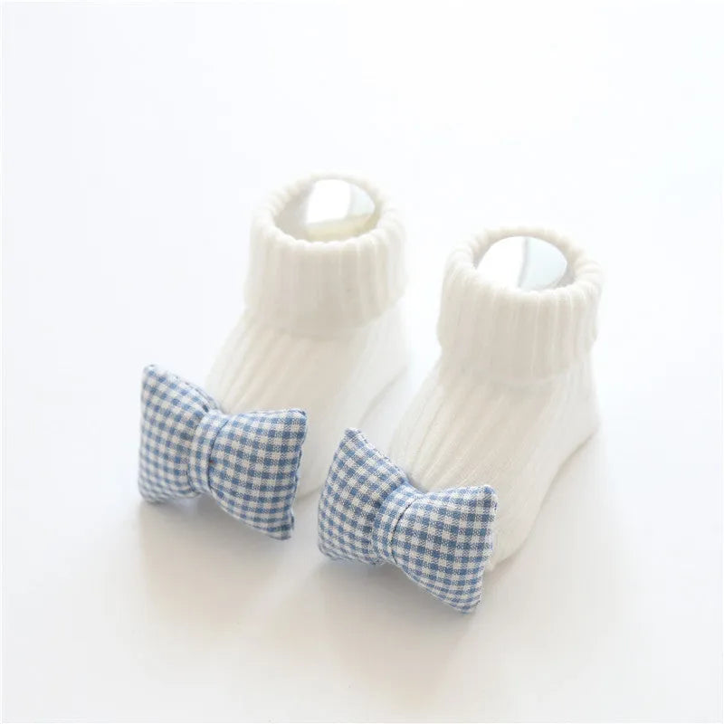 Cotton baby floor socks in various colours and patterns including pink bows, grey stars, and panda design.