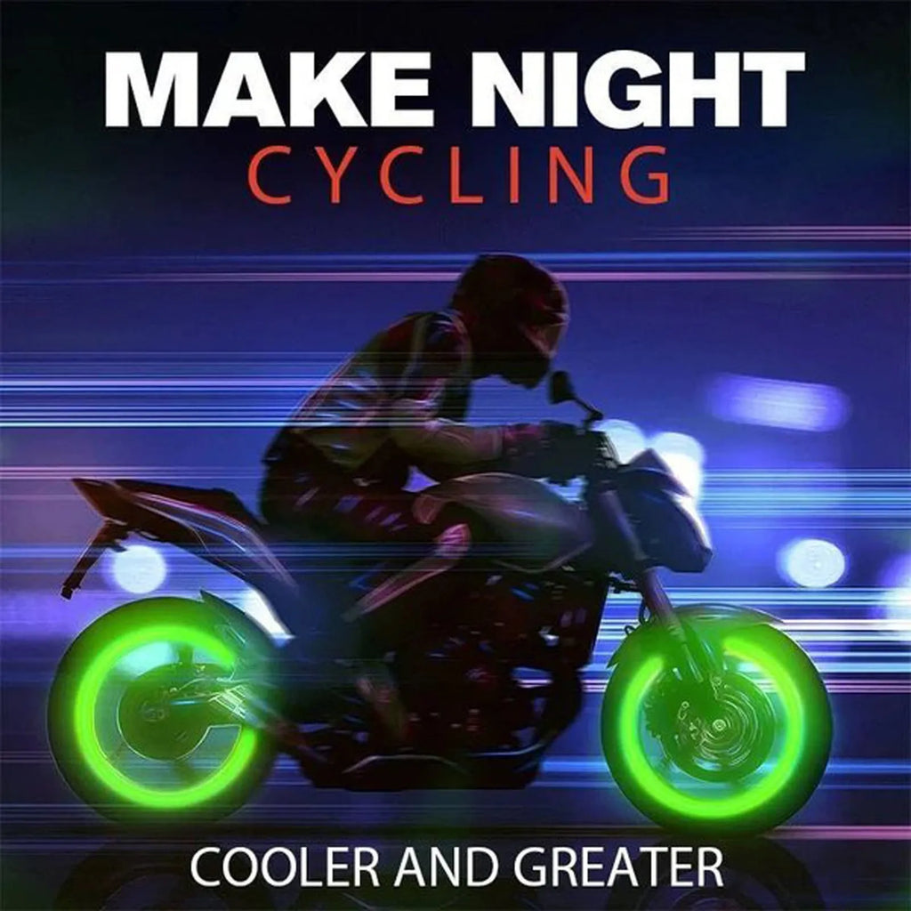 Set of four glowing green LED tyre valve caps screwed onto a car wheel valve stems at night.