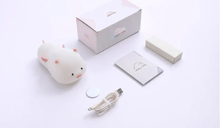 Blue rechargeable silicone night light shaped like a sleeping pig with soft LED glow.