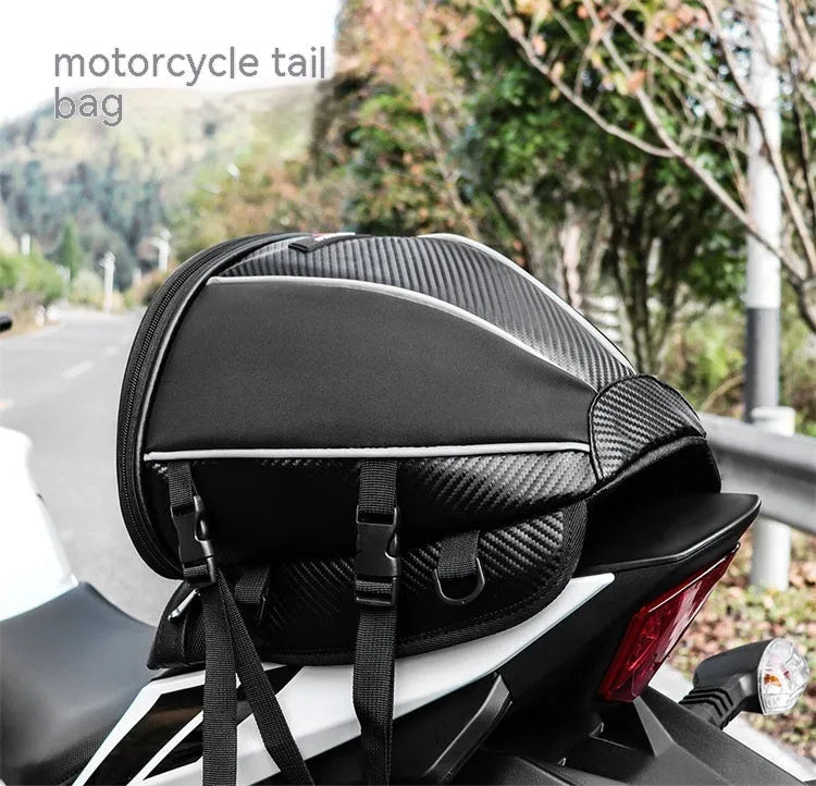 Black motorcycle seat bag with reflective strips, shown with carrying strap.