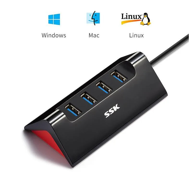 Black plastic USB hub with four USB-A ports and a Micro USB power port on a desk.