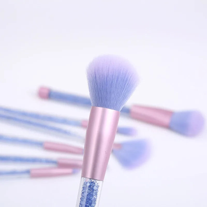Set of 7 makeup brushes with pink handles, black bristles, and long plastic handles on a light background