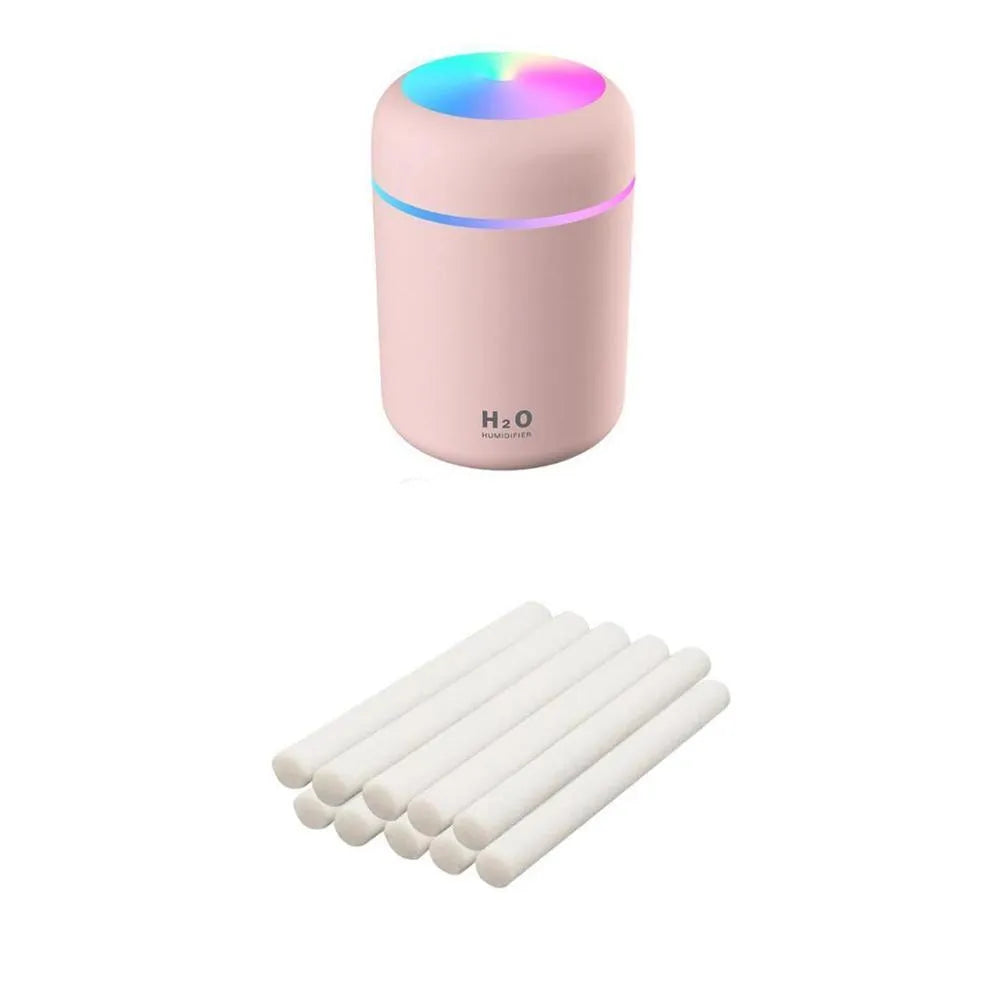 Pink, white, and navy blue USB mini silent humidifier with LED lights on a desk