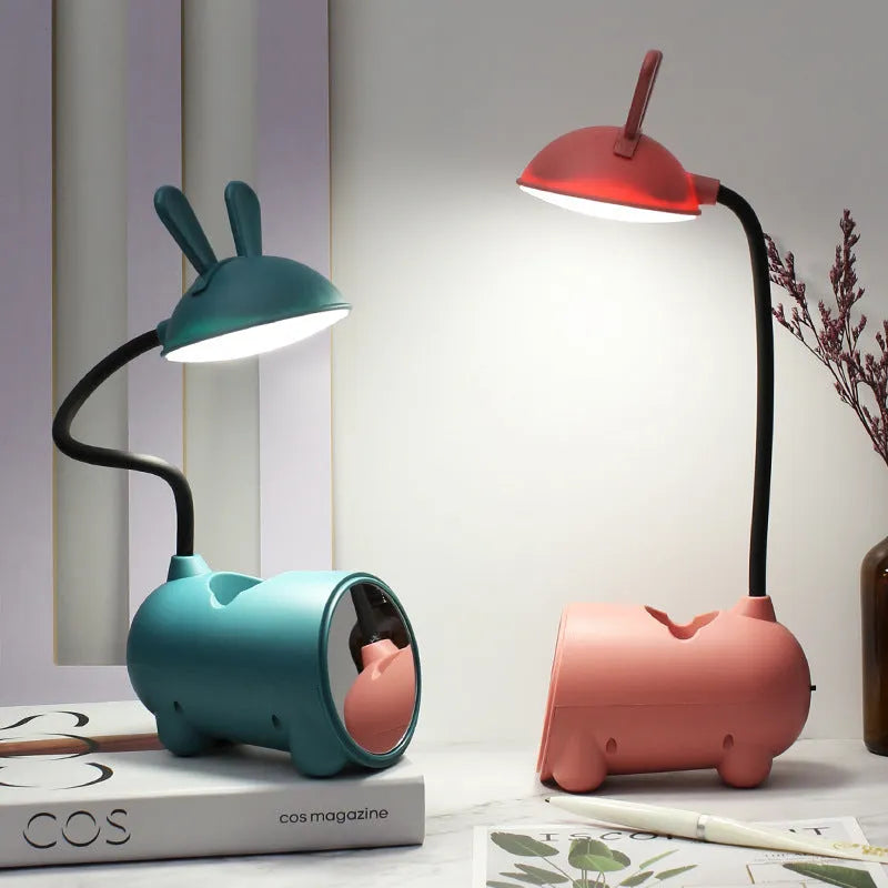 Cartoon-style USB table lamp with integrated pen container in green colour on wooden desk