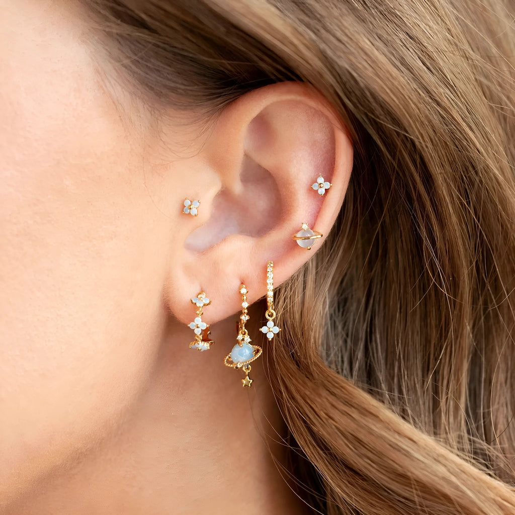 Gold and silver flower-shaped ear studs with zircon mosaic detail on a white background.