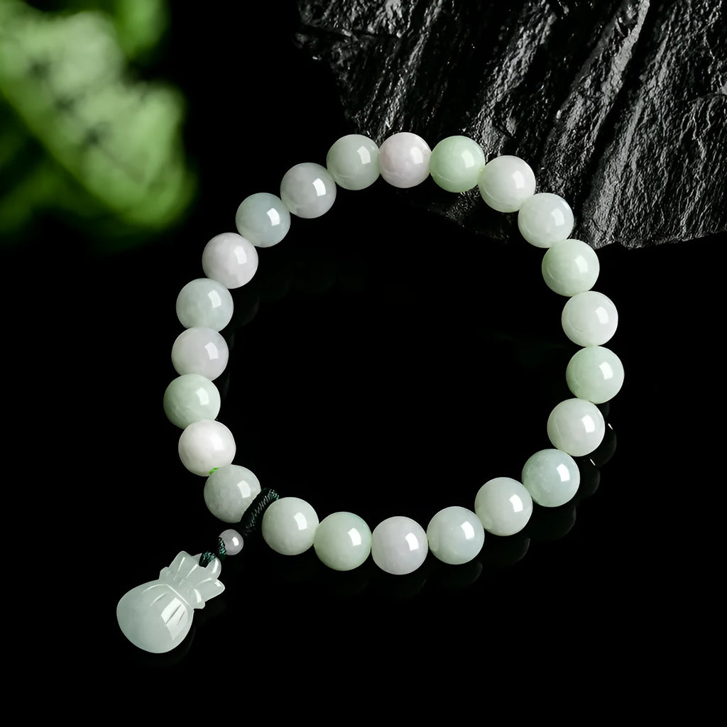 Close-up of an 8mm floral carved jade bracelet on a wrist.
