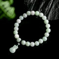 Close-up of an 8mm floral carved jade bracelet on a wrist.