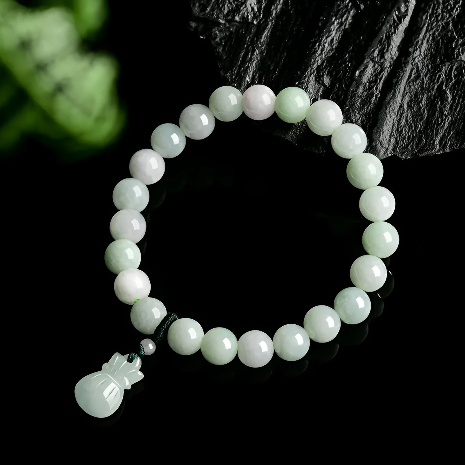 Close-up of an 8mm floral carved jade bracelet on a wrist.