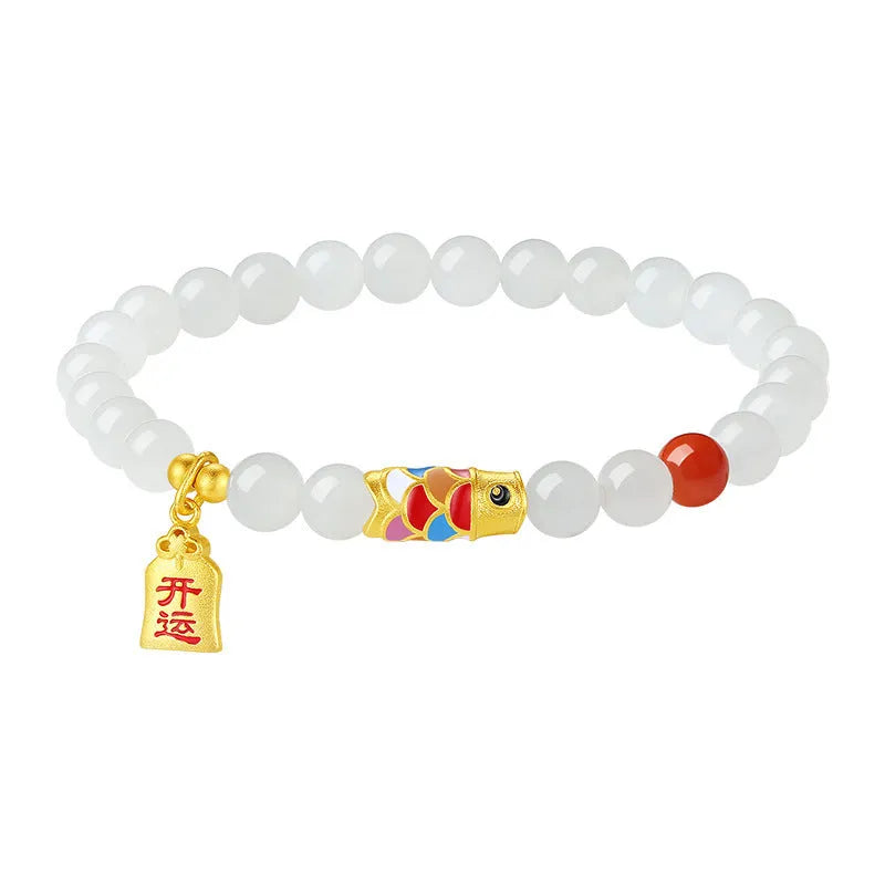 Close-up of a sterling silver bracelet with a blue and orange cold enamel koi fish charm set with Hetian jade.