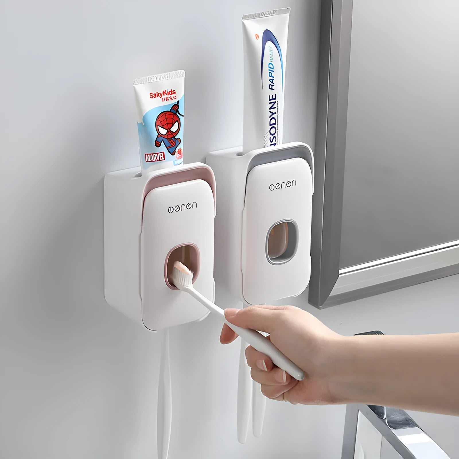 Blue automatic wall-mounted toothpaste dispenser with a sensor for touchless operation on a bathroom wall.