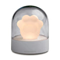 Grey cat paw shaped USB rechargeable musical night light on a wooden desk