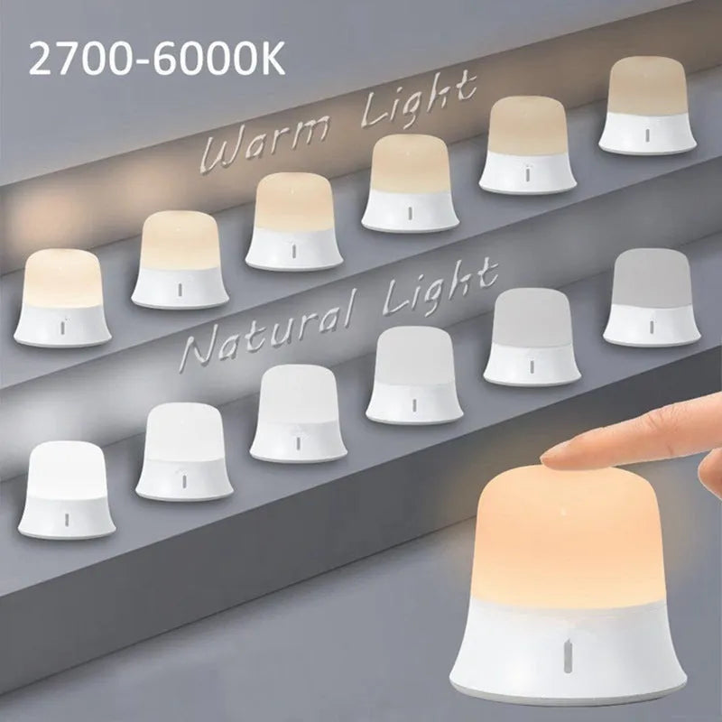 White touch control bedside night light with rechargeable battery and motion sensor on a table.