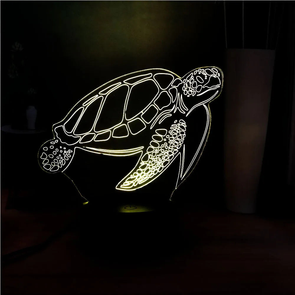 3D acrylic turtle shaped LED night light showing multi-coloured illumination on a shelf.