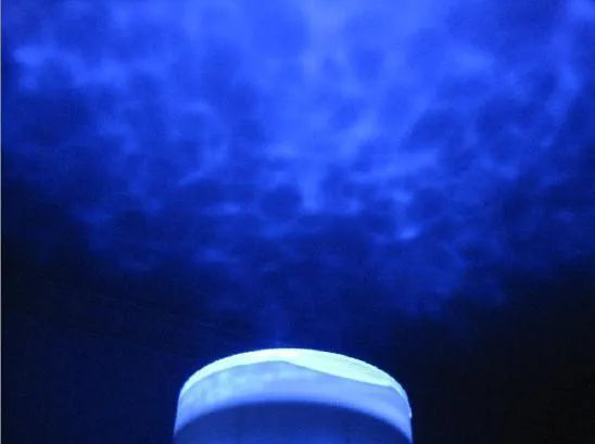 A blue ocean-themed LED projection lamp displaying a 2D oceanic scene on a wall.