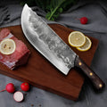 Hand forged stainless steel butcher knife with chicken wing wood handle and copper nails on a cutting board