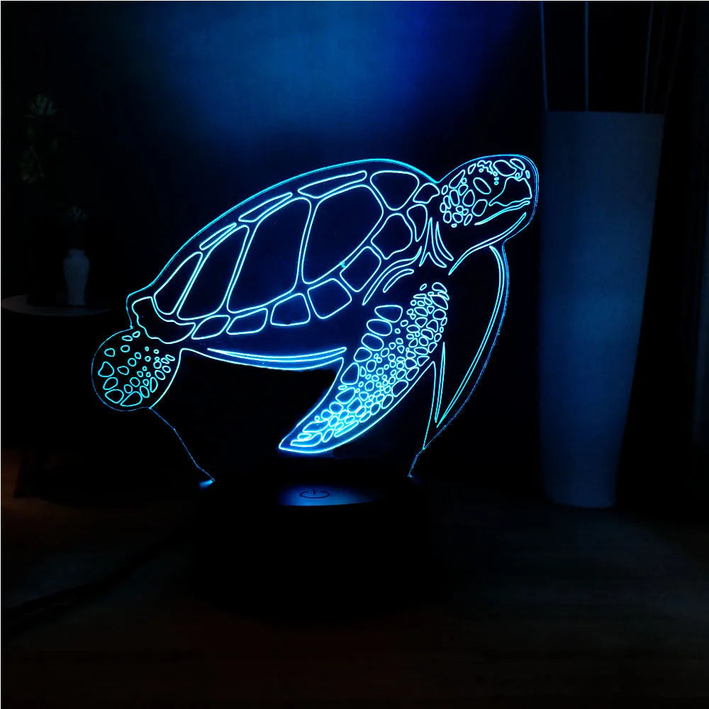 3D acrylic turtle shaped LED night light showing multi-coloured illumination on a shelf.