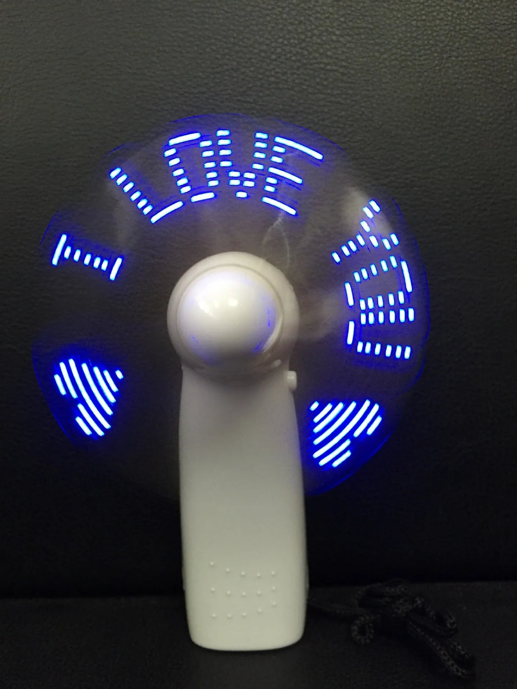 White handheld mini fan displaying a red flashing 'I Love You' LED pattern on its front panel.