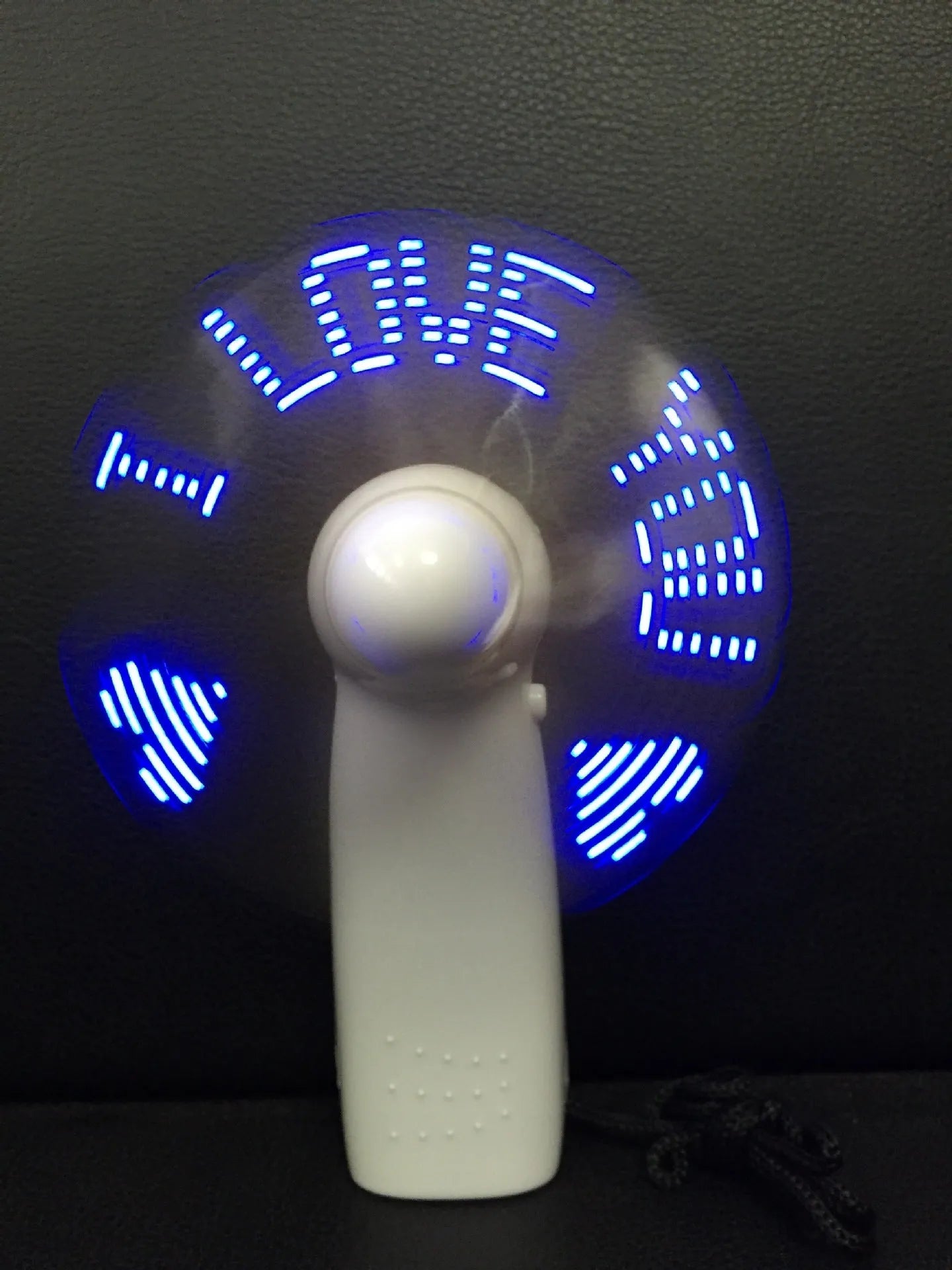 White handheld mini fan displaying a red flashing 'I Love You' LED pattern on its front panel.