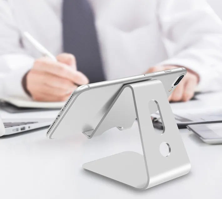 Universal Phone Buddy metal aluminium alloy stand holding a phone on a desk, available in multiple colours