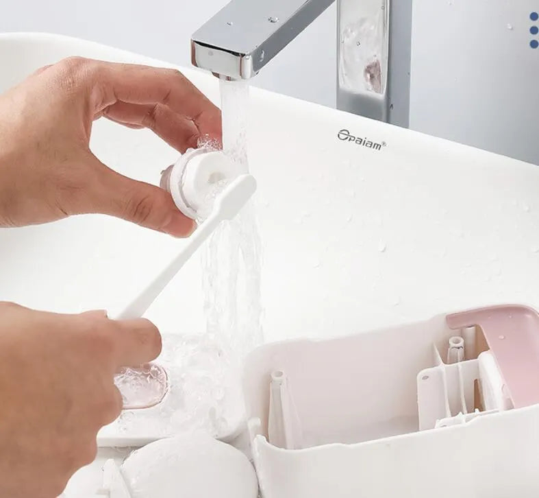 Blue automatic wall-mounted toothpaste dispenser with a sensor for touchless operation on a bathroom wall.