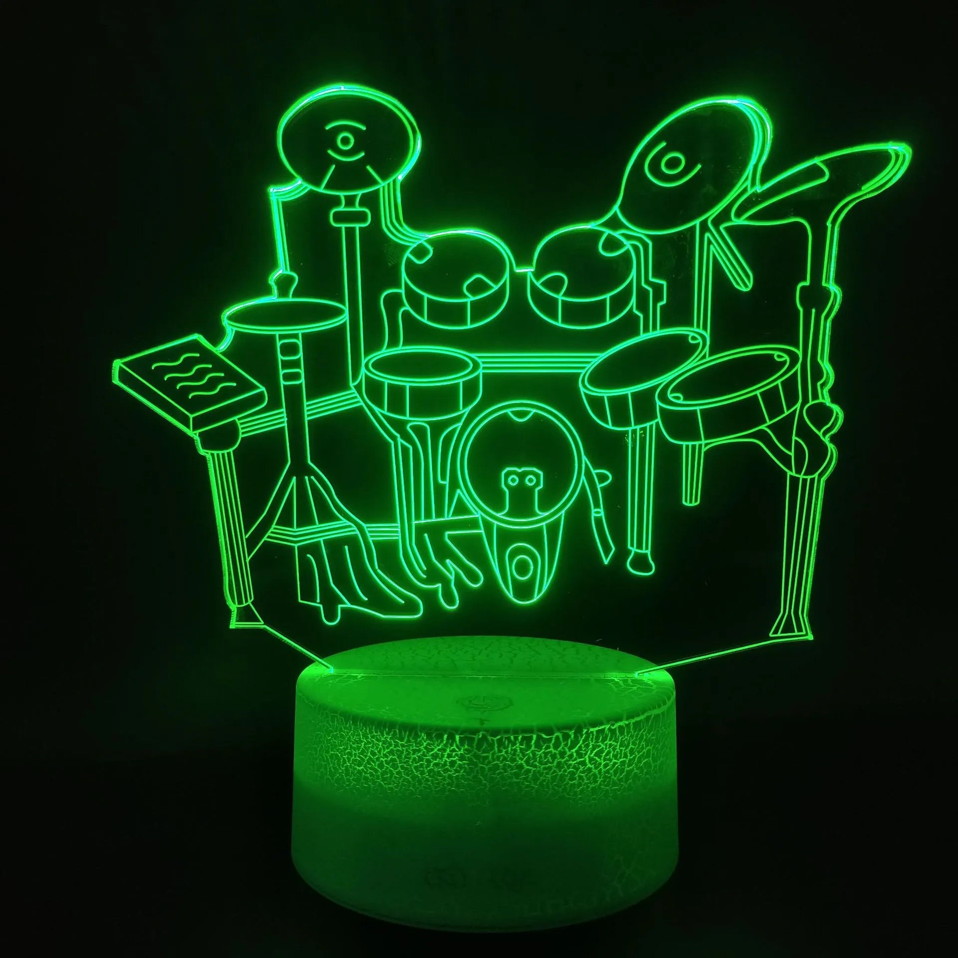 Drum kit shaped 3D LED night light with colourful illumination on a dark surface.