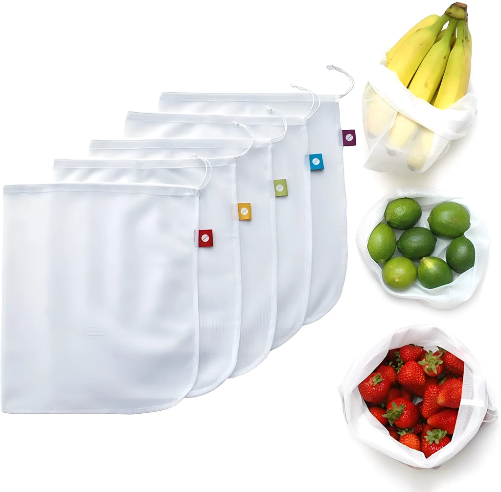 Five white cotton drawstring bags for kitchen vegetable storage arranged on a clean surface