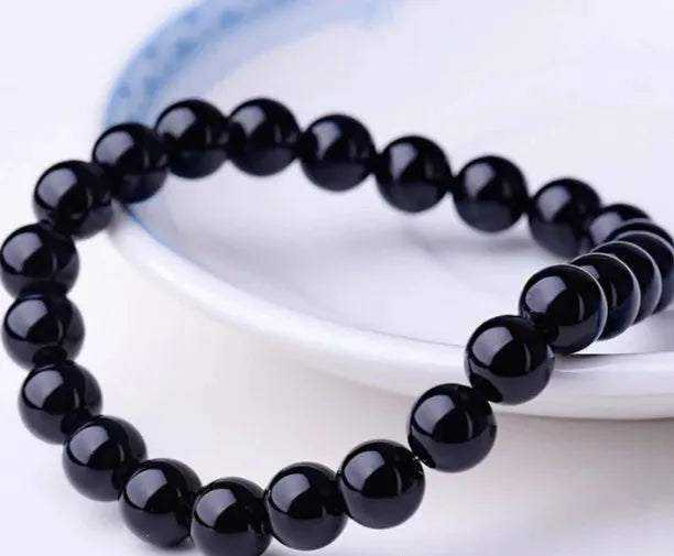 Women's geometric black agate bracelet with elastic cord, shown in 8mm bead size.
