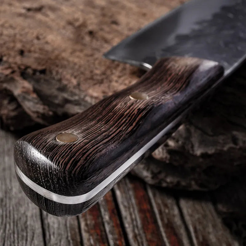 Hand forged stainless steel butcher knife with chicken wing wood handle and copper nails on a cutting board
