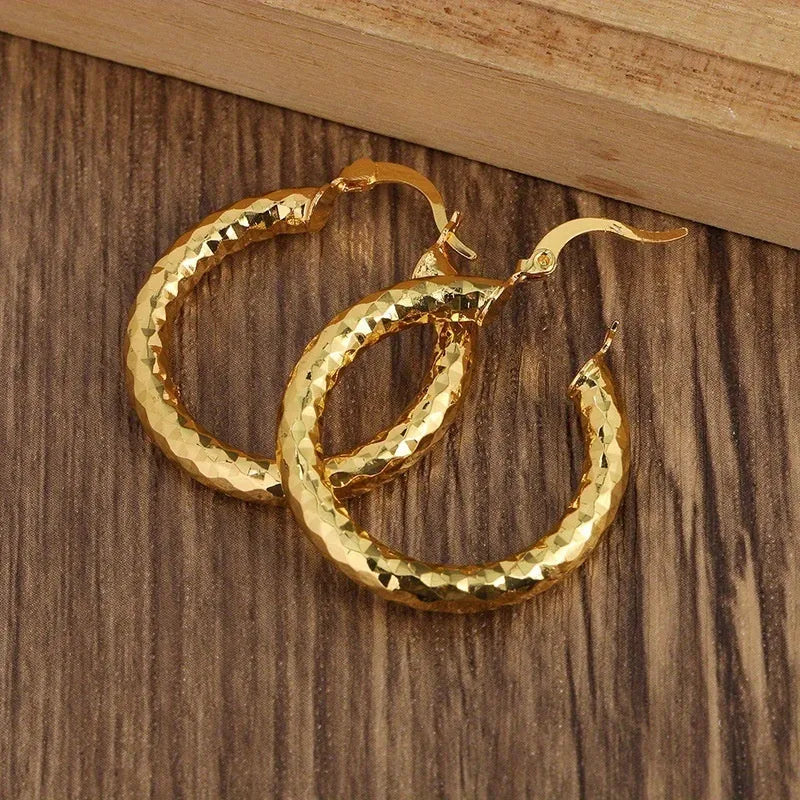 Pair of gold-coloured retro classic alloy earrings for women on a neutral background