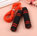 Adjustable Jump Fit Rope with black weighted handles and red speed rope on a dark workout mat