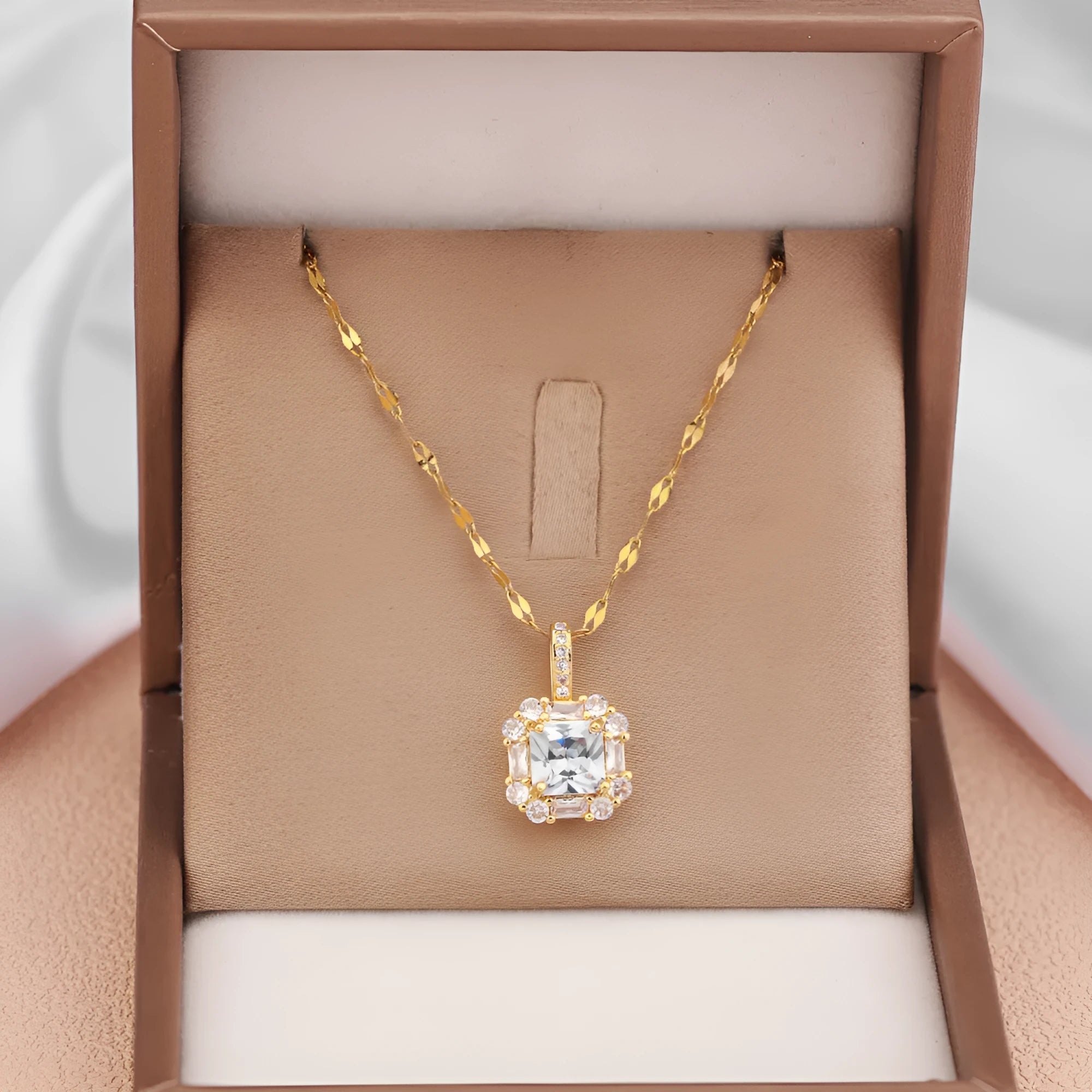 Gold geometric quadrilateral pendant necklace with gem inlay on a water wave chain.