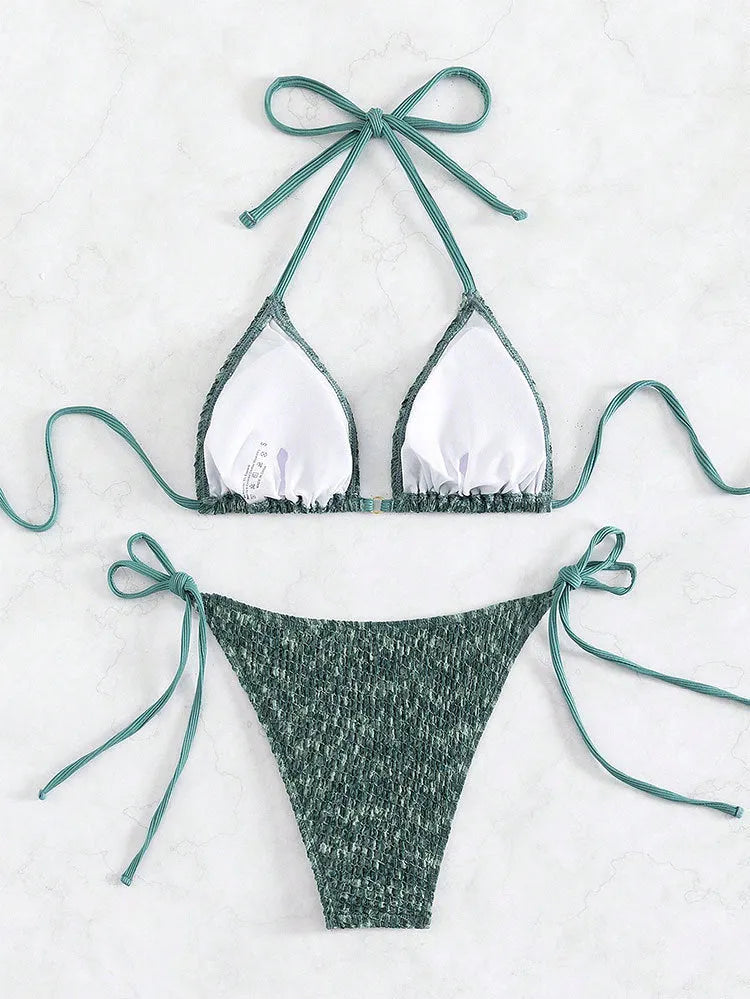 Green backless women's bikini set with halter neck strap and matching shorts.
