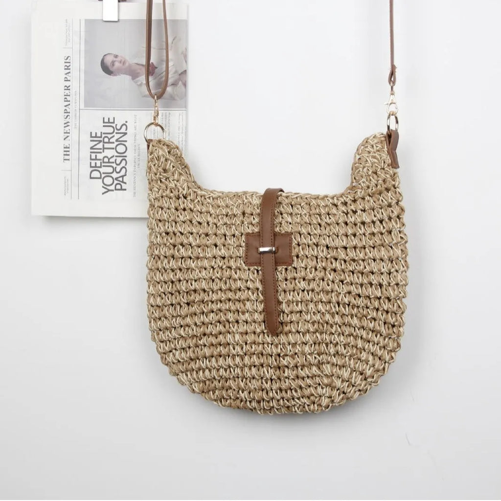 Handmade beige square woven bag with a shoulder strap on a neutral background.