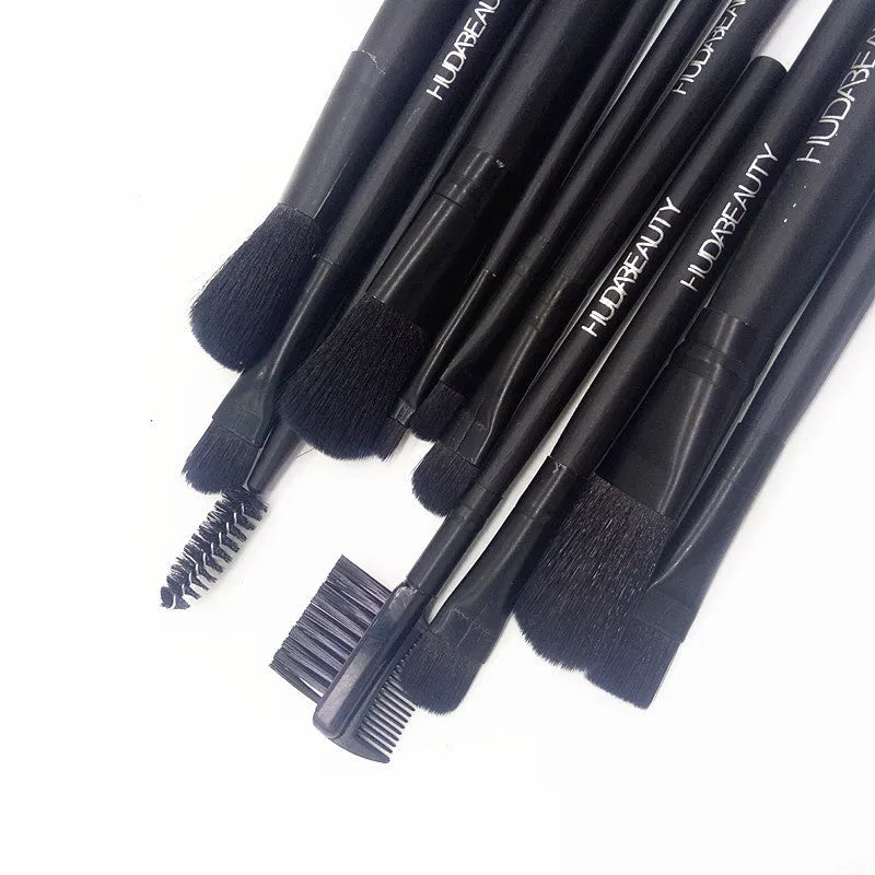 12 black makeup brushes in a tin box with nylon bristles and wooden handles on a white background