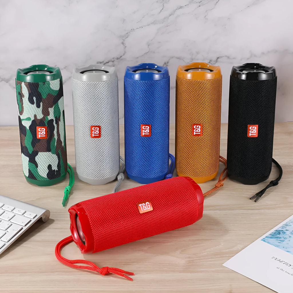 Fabric-covered portable Bluetooth speaker with a visible card slot in colours blue, black, red, gold, silver grey, and camouflage.
