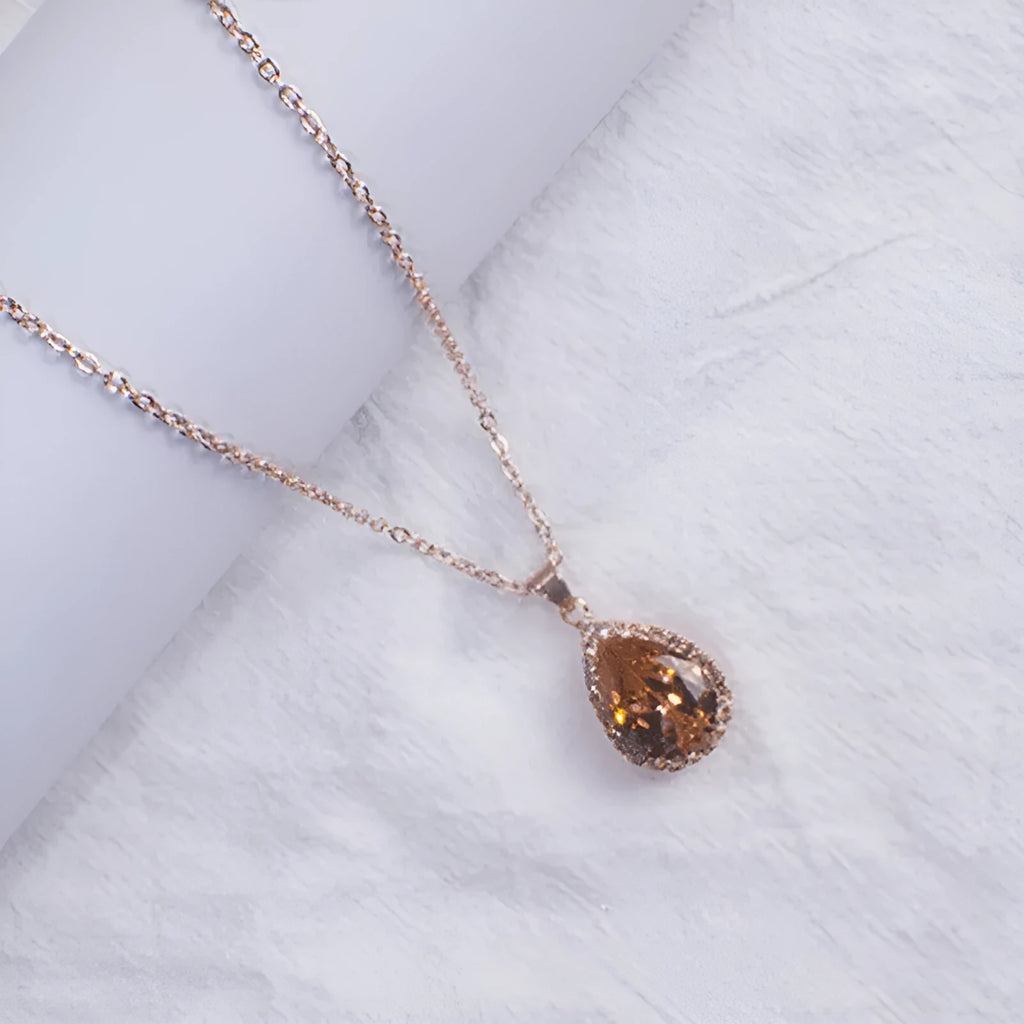 Women's water drop shaped pink necklace with rose gold rhinestone geometric detailing on alloy chain