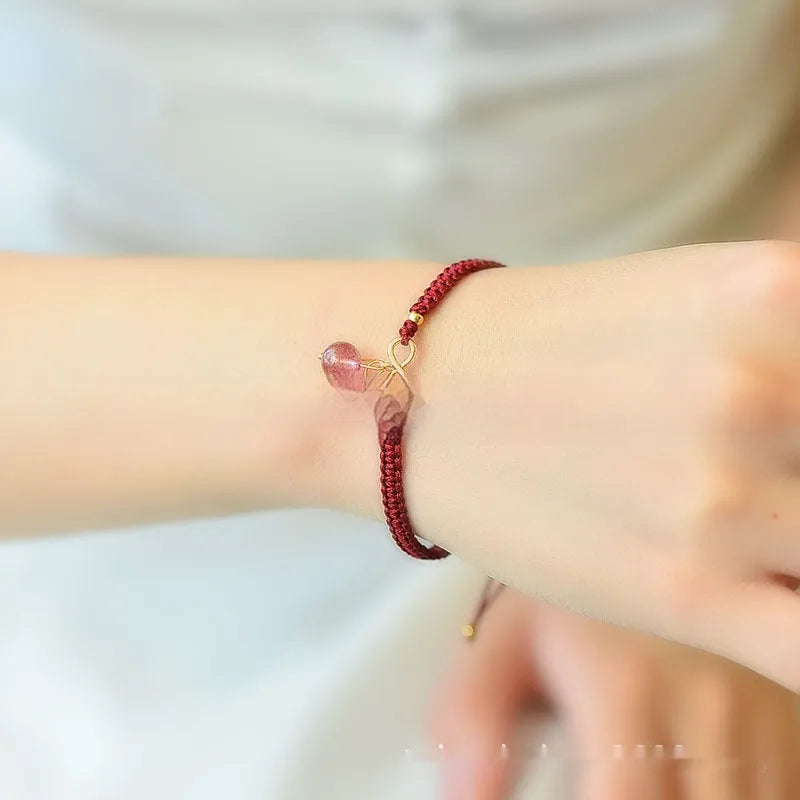 Women's natural strawberry quartz bracelet with a detailed cherry-shaped crystal charm.