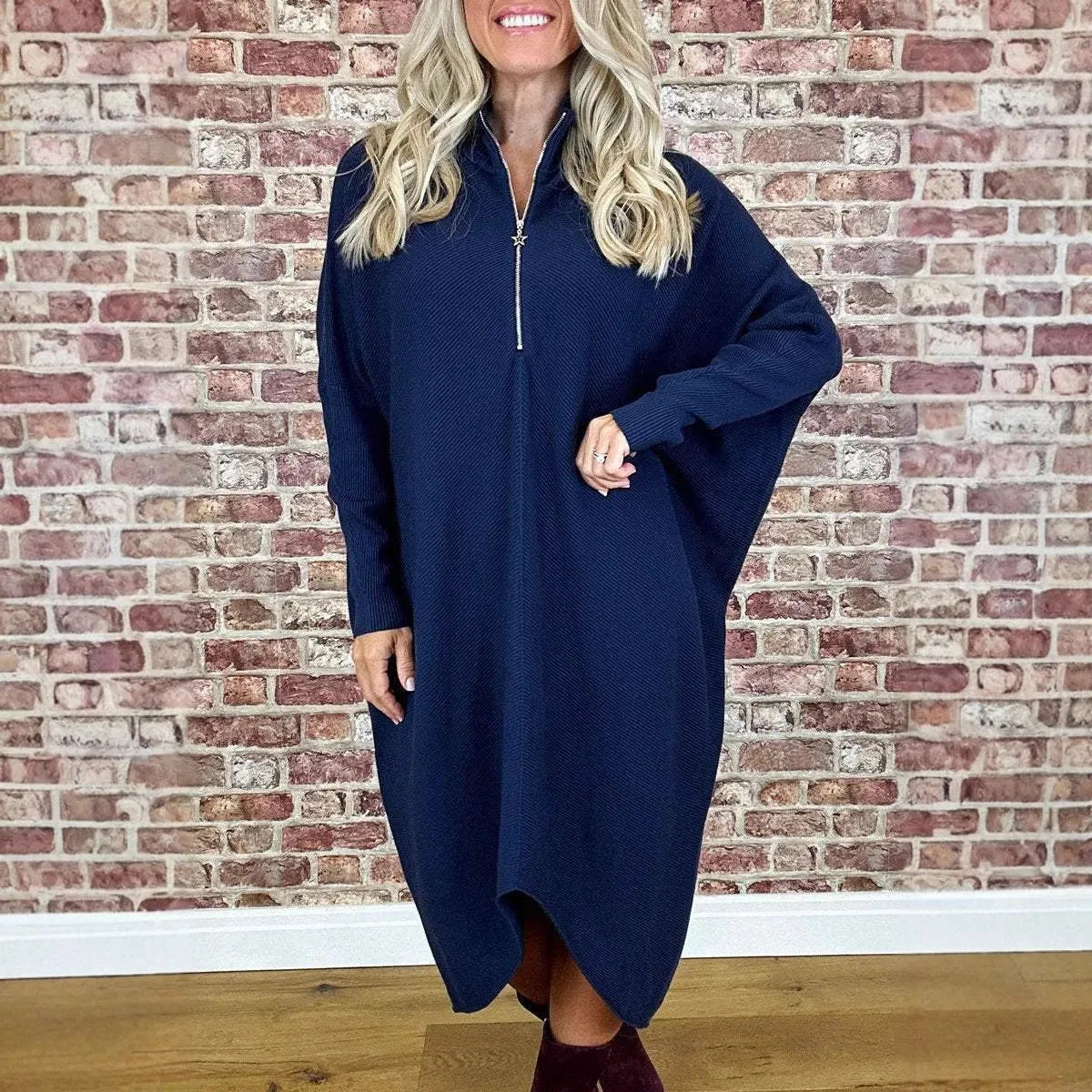 Women's solid colour loose fit knitted dress with raglan sleeves on a hanger.