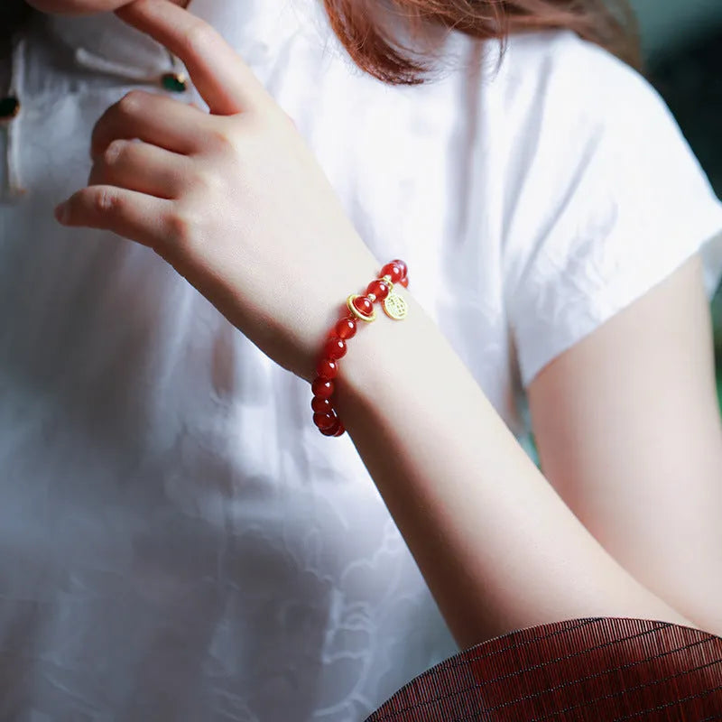 Natural red agate bracelet with woven bead design on a wrist.